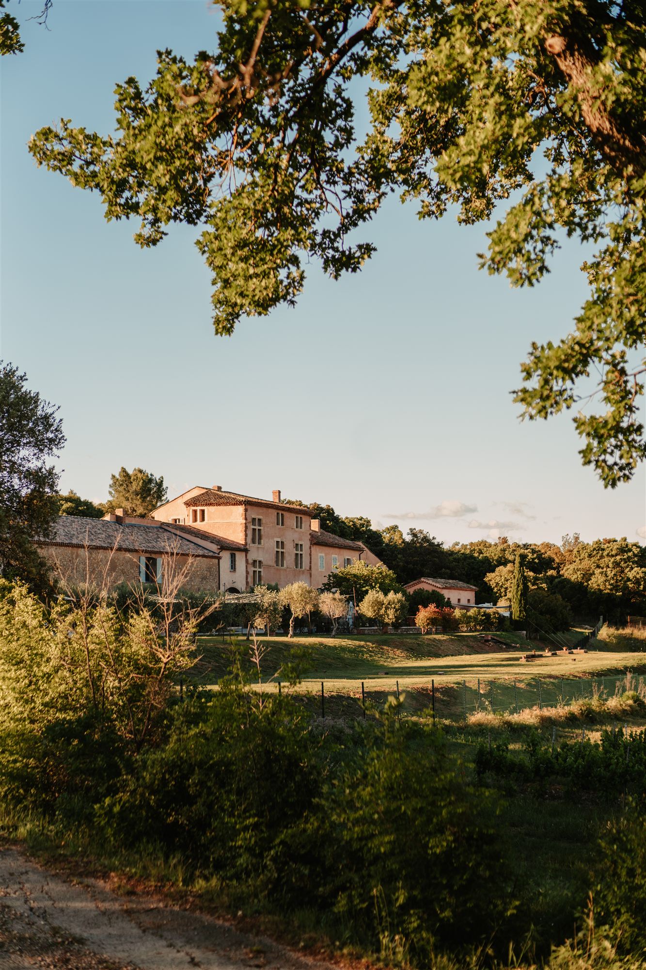 Domaine Miolan au coucher du soleil, façade provençale entourée d'arbres, dans le Var